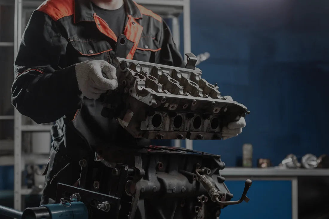 Person working on an engine in a workshop setting